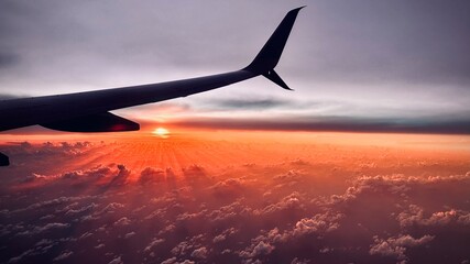 sunrise or sunset from the pane flying over the clouds