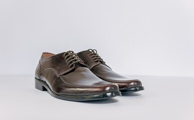 Classic male brown leather shoes isolated over white background, front and a little side view. Able to add some text