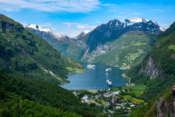 Fototapeta na wymiar Views of Norwegian fjord landscape with snow mountains and cruise ships in Geiranger fjord, Norway