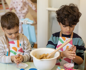 Kids prepering food in the montessori  kindergarten,  banana cokies