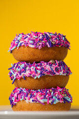 Stack of colorful sprinkle birthday donuts