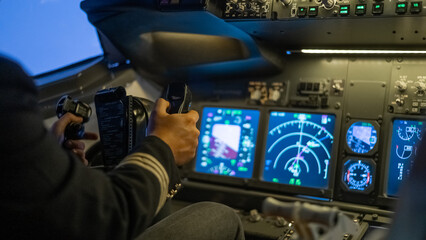 A man is studying to be a pilot in a flight simulator. Close-up of male hands navigating an...