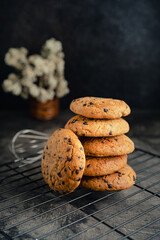 Homemade chocolate chip cookies on black baking cooling tray and abstract background