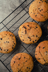 Homemade chocolate chip cookies on black baking cooling tray and abstract background