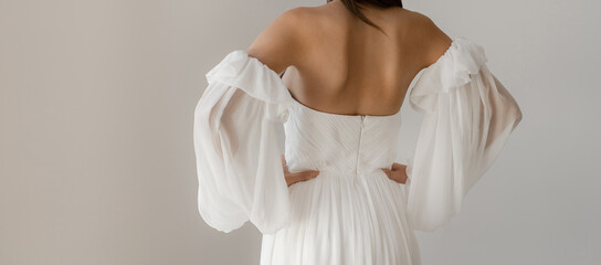 Gorgeous long wedding backless dress. Bride in the shoulderless white wedding dress with fancy...