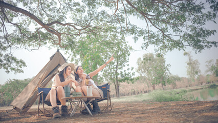 two women take a photo and camping in the forest 