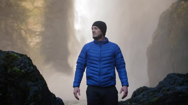 Adventurous Man Standing Under Amazing Waterfall
