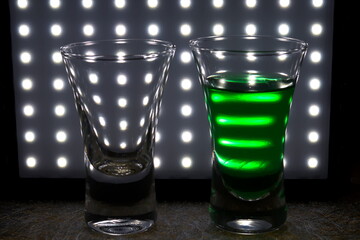empty glass and glass with  mint liquer shot glass against club lights. night life. vacation style. Summer heat and relaxe. bar concept.
