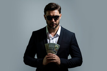 Portrait business man holding cash dollar bills over gray background. Big luck, banner. Dollar cash...