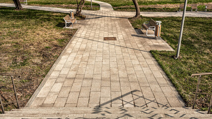 Fototapeta premium Park landscape with stair, walking paths, benches for relaxing on a sunny spring day.