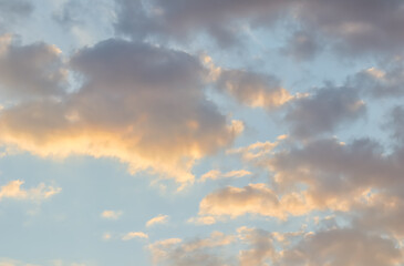Blue sky background with golden clouds at sunset