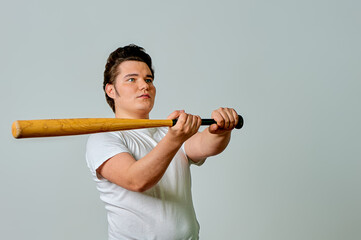 A man with a bat in his hands swings on a gray background