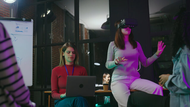 Young woman wearing vr and talking with team at meeting room.  Technology, Lifestyle, Business, Metaverse, Development and Industry concept.