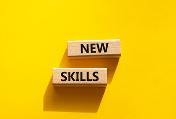 New skills symbol. Wooden blocks with words New skills. Beautiful yellow background. Business and New skills concept. Copy space.
