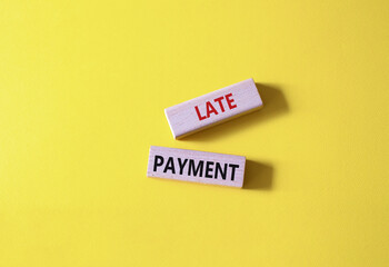 Late payment symbol. Concept word Late payment on wooden blocks. Beautiful yellow background. Business and Late payment concept. Copy space
