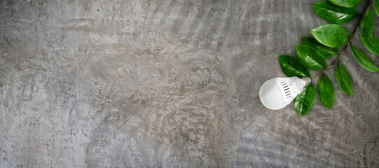 LED light bulb on a background of green leaves, as a symbol of green energy, energy saving and environmental care. Energy conservation concept.