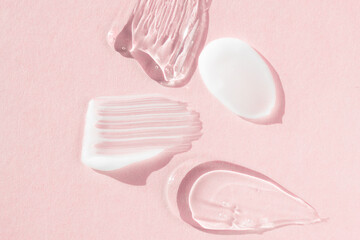 Fototapeta na wymiar Cream and hyaluron samples, smears on a pink background. Dermatological and cosmetic product, macro.