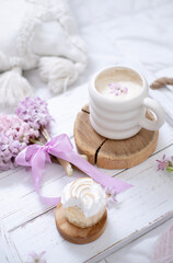 Obraz na płótnie Canvas A cup of warm aromatic coffee on a tray and hyacinth flowers