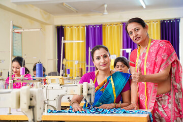 Young Indian woman doing guidance to women group at textile factory.