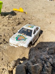 Different child plastic toys on sandy beach - 591375023