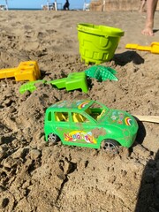 Different child plastic toys on sandy beach - 591376663