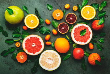Citrus fruit food background, top view. Mix of different whole and sliced fruits: orange,...