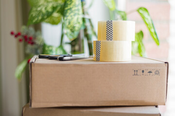 boxes for moving and delivery as well as scotch tape and an office knife with scissors