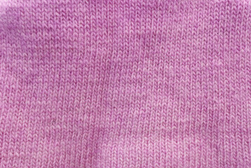 Pink knitted fabric texture or background for a design with room for copying text or images. 