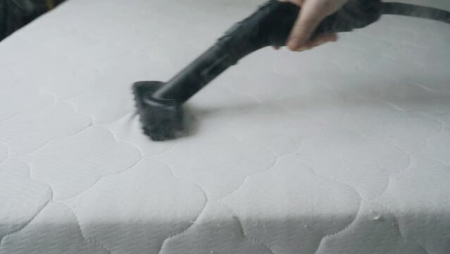 Close-up. Cleaning the mattress with a steam cleaner. Heat treatment and cleaning from dirt and insects of bedding.
