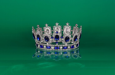 crown with precious stones isolated on green background