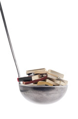 a ladle full of books on a transparent surface	