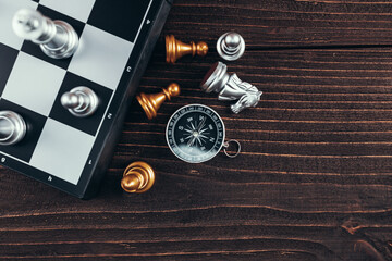 compass and chess piece on chess board game for ideas, challenge, leadership, strategy, business,...