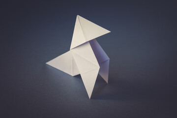 White paper hen origami isolated on a grey background