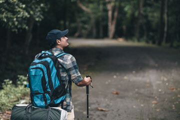 Hikers use trekking pole with backpacks on the road in the forest. hiking and adventure concept.