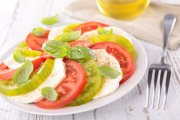 tomato salad- slices of green and red tomato with slice of mozzarella and basil- Caprese salad