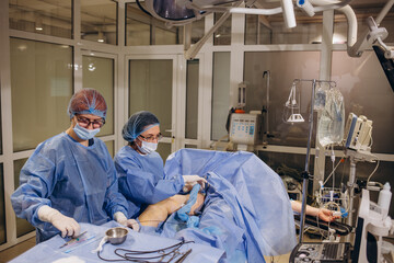 doctor and an assistant in the operating room for surgical venous vascular surgery clinic
