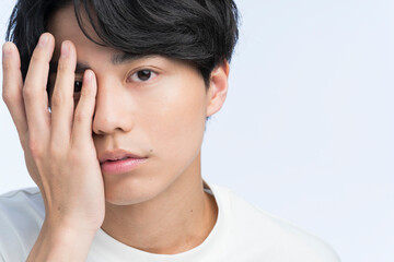メンズビューティー /半顔を手で隠している若い男性	