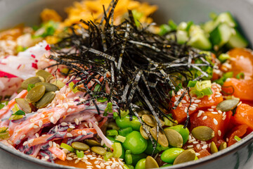 Fototapeta na wymiar Portion of gourmet salmon poke bowl with vegetables