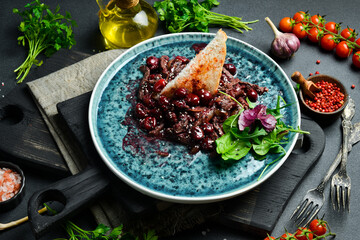 Stewed veal with cherry, cherry sauce and sesame. Free space for text. Close up.