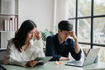 Fototapeta premium ..Furious two Asian businesspeople arguing strongly after making a mistake at work in office