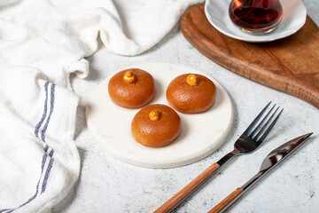 Sekerpare dessert. Turkish Ramadan dessert. Sekerpare dessert with sherbet on a marble serving plate