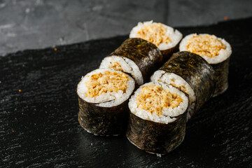 sushi roll maki with baked tuna on a dark background