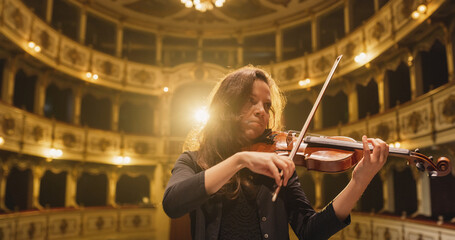 Cinematic Portrait of Female Violinist Playing Violin in an Orchestra Show on the Stage of a...