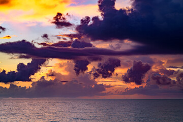 Clouds over the sea, sunrise. Sea wave. Colorful beach sunrise with calm waves. Nature sea sky. Sunrise with clouds of different colors against the blue sky and sea.
