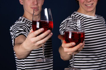 Two young attractive guys are drinking red wine.