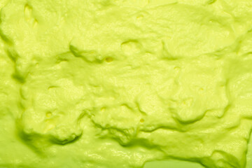 Cake cream texture, sweet whipped cream. Background of yogurt close-up with a pattern. Pistachio mousse.