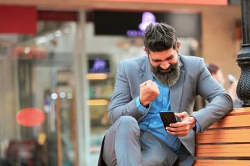 Indian businessman using smartphone and giving expression.