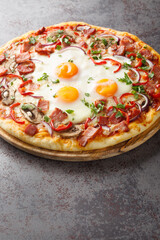 Australian traditional pizza with ham and eggs close-up on a wooden board on the table. Vertical