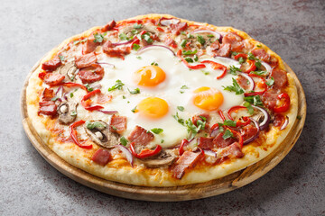 Hot pizza with bacon, eggs, peppers, mushrooms, mozzarella and red onions close-up on a wooden board on the table. Horizontal