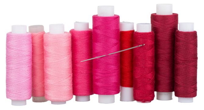 Spools with pink red purple thread and needle for sewing, supply for sewing, isolated objects 
